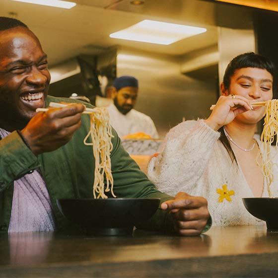 Friends sharing bowls of noodles at wagamama Covent Garden